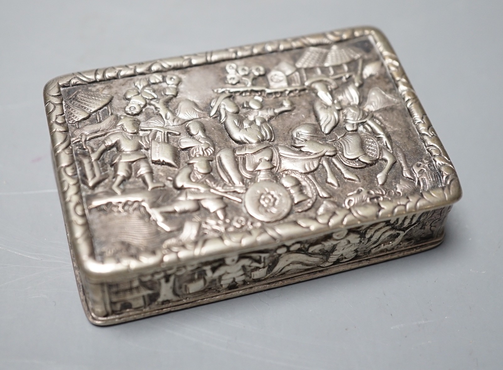A Chinese export white metal snuff box, maker YS, 66mm, embossed with figures at various pursuits.